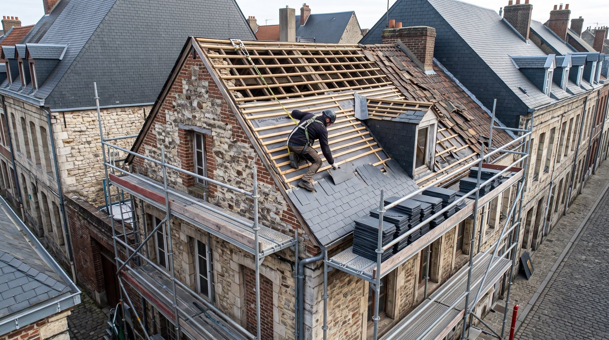 Charpente traditionnelle en bois vue depuis des combles non aménagés, chevrons et pannes apparents